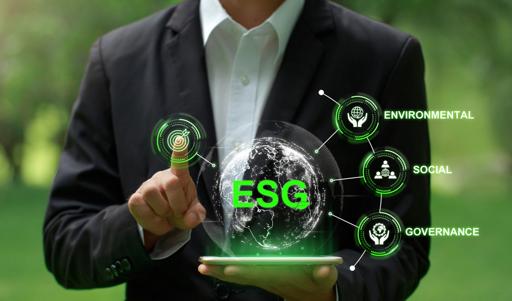 Uomo d'affari con tablet in mano che interagisce con interfaccia digitale ESG simbolo di sostenibilità e responsabilità aziendale e sociale.